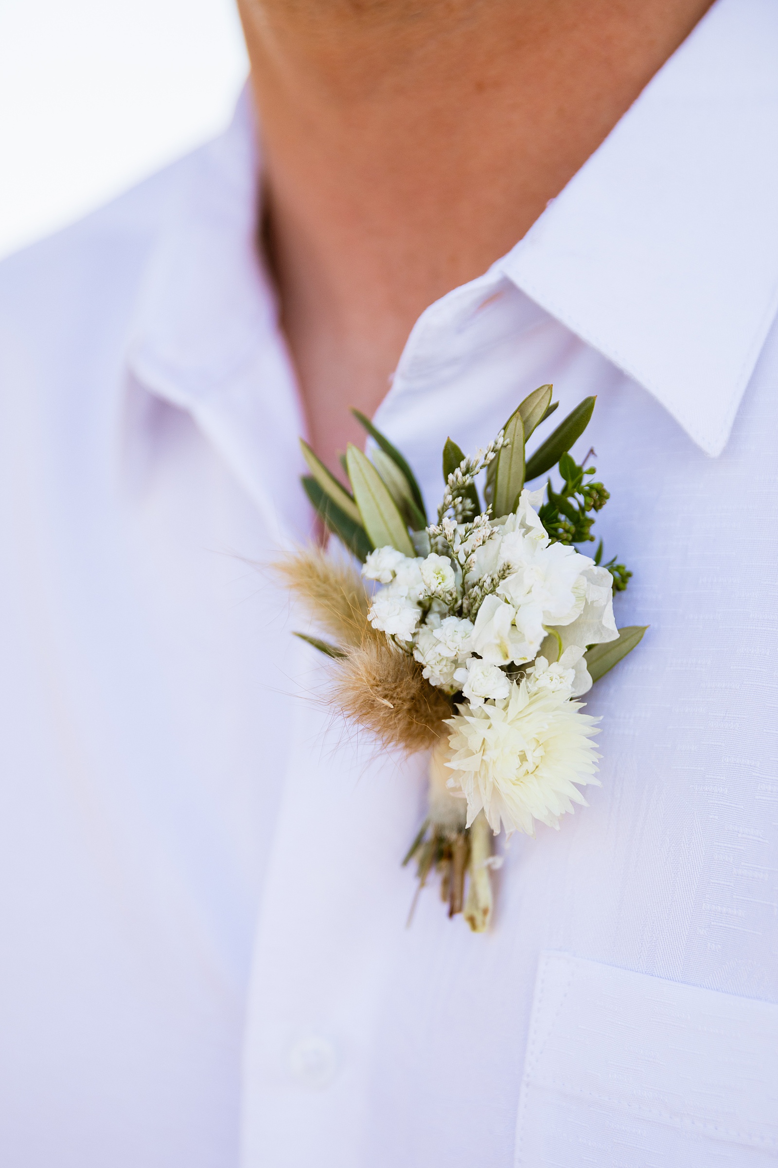 Groom's white and cream wild, freeform boutonniere by PMA Photography.