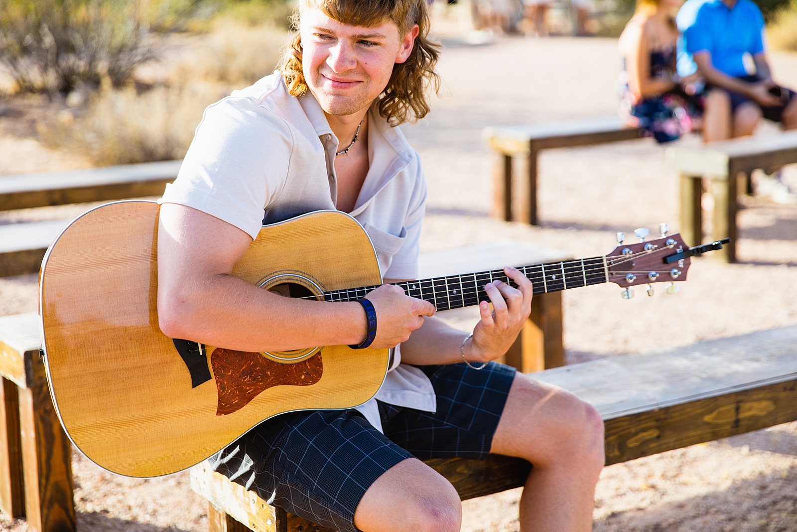 The bride's brother playing guitar during Superstition Mountain Micro wedding ceremony by Phoenix wedding photographer PMA Photography.