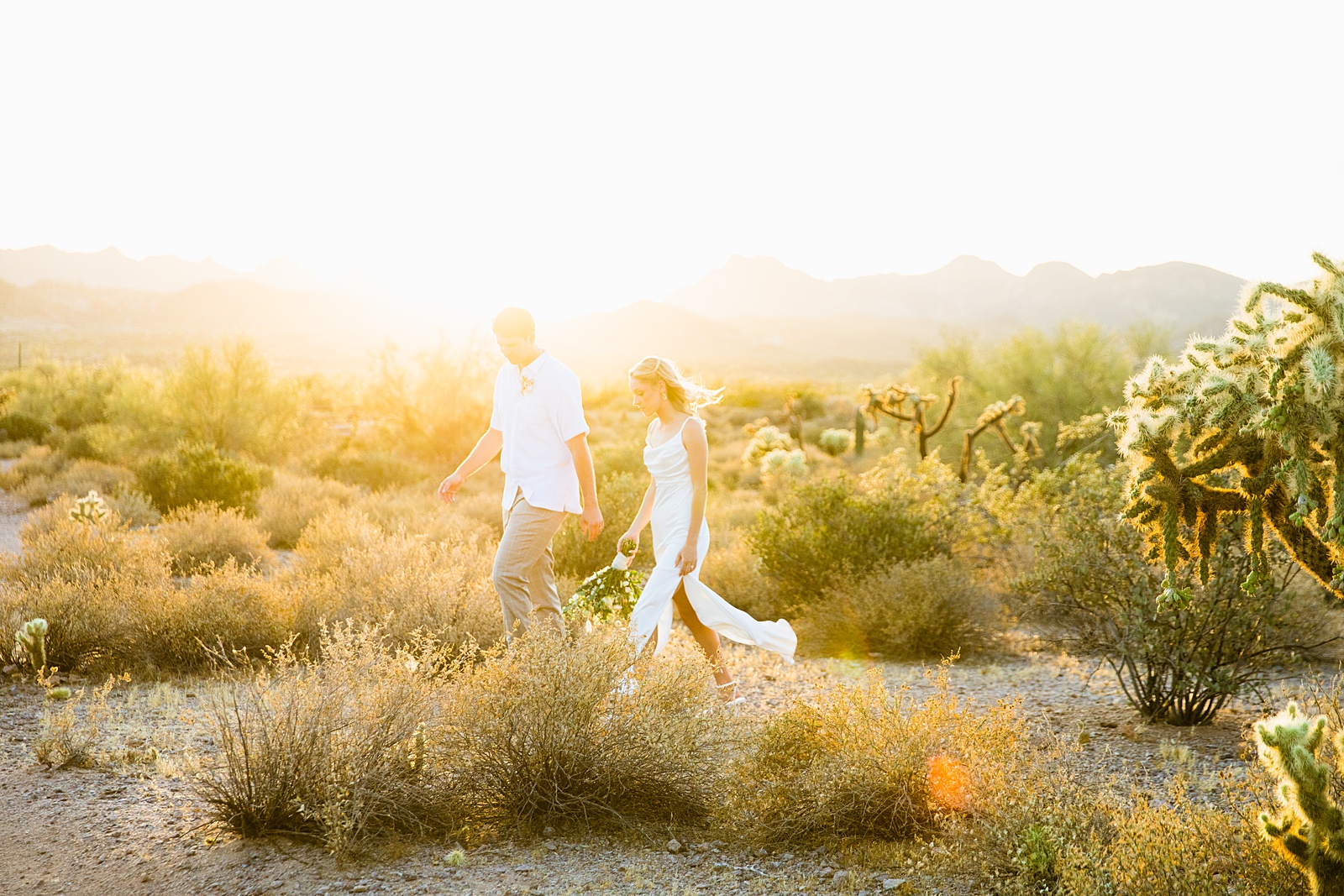 Bride and Groom walking together during their Superstition Mountain Micro wedding by Arizona wedding photographer PMA Photography.