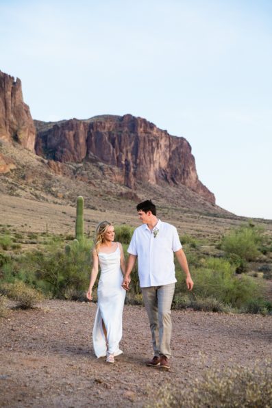 Bride and groom walking together during their Superstition Mountain Micro wedding by Arizona wedding photographer PMA Photography.