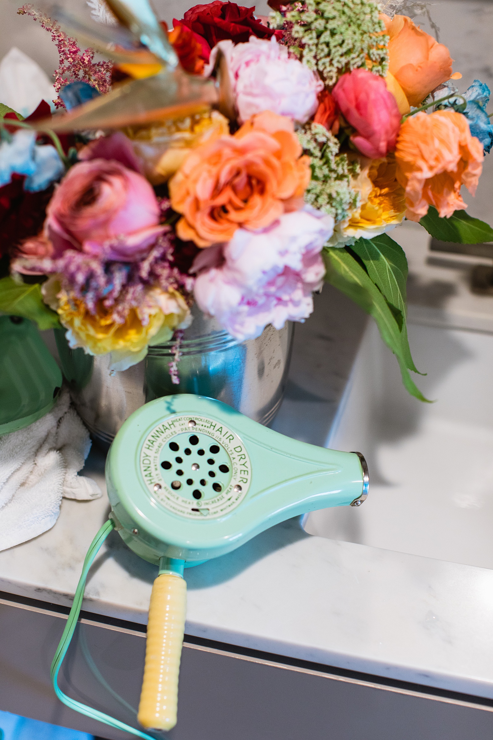 Brides's wedding day details of bouquet and retro hair dryer by PMA Photography.