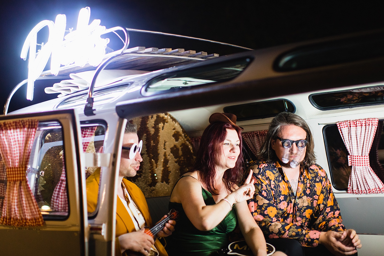 Groom and guests take photos in retro VW Bus photo booth at Mountain Shadows Resort wedding reception by Paradise Valley wedding photographer PMA Photography