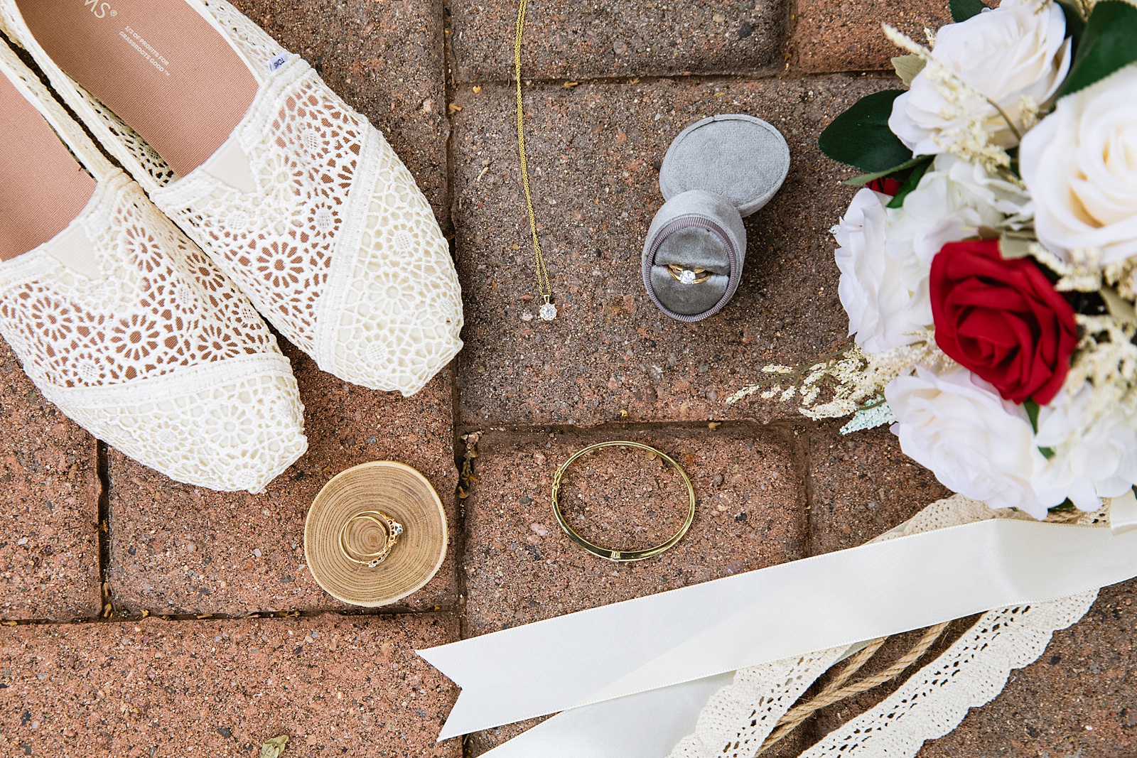 Bride's wedding day details of lace shoes, jewelry, wedding rings and bouquet by PMA Photography.