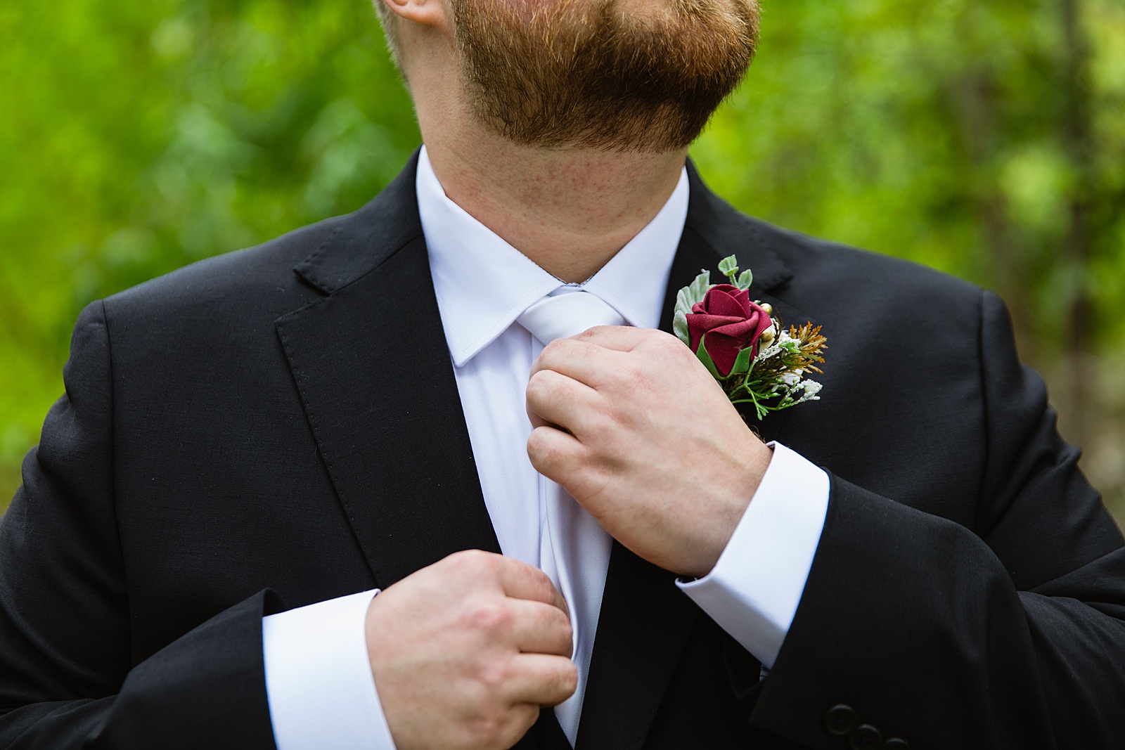 Groom adjusting his tie for his wedding day by Sedona wedding photographers PMA Photography.