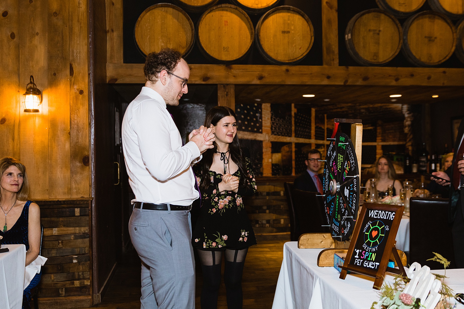 Wedding guests play spin the wheel at Timo Wood Oven Wine Bar wedding reception by Arizona wedding photographer PMA Photography.