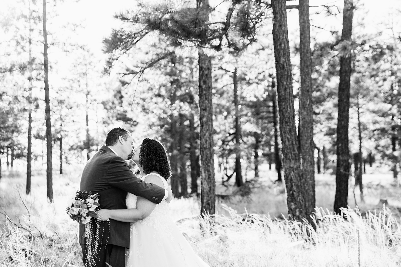 Adventurous couple share a kiss during their Mogollon Rim elopement by Arizona elopement photographer PMA Photography.