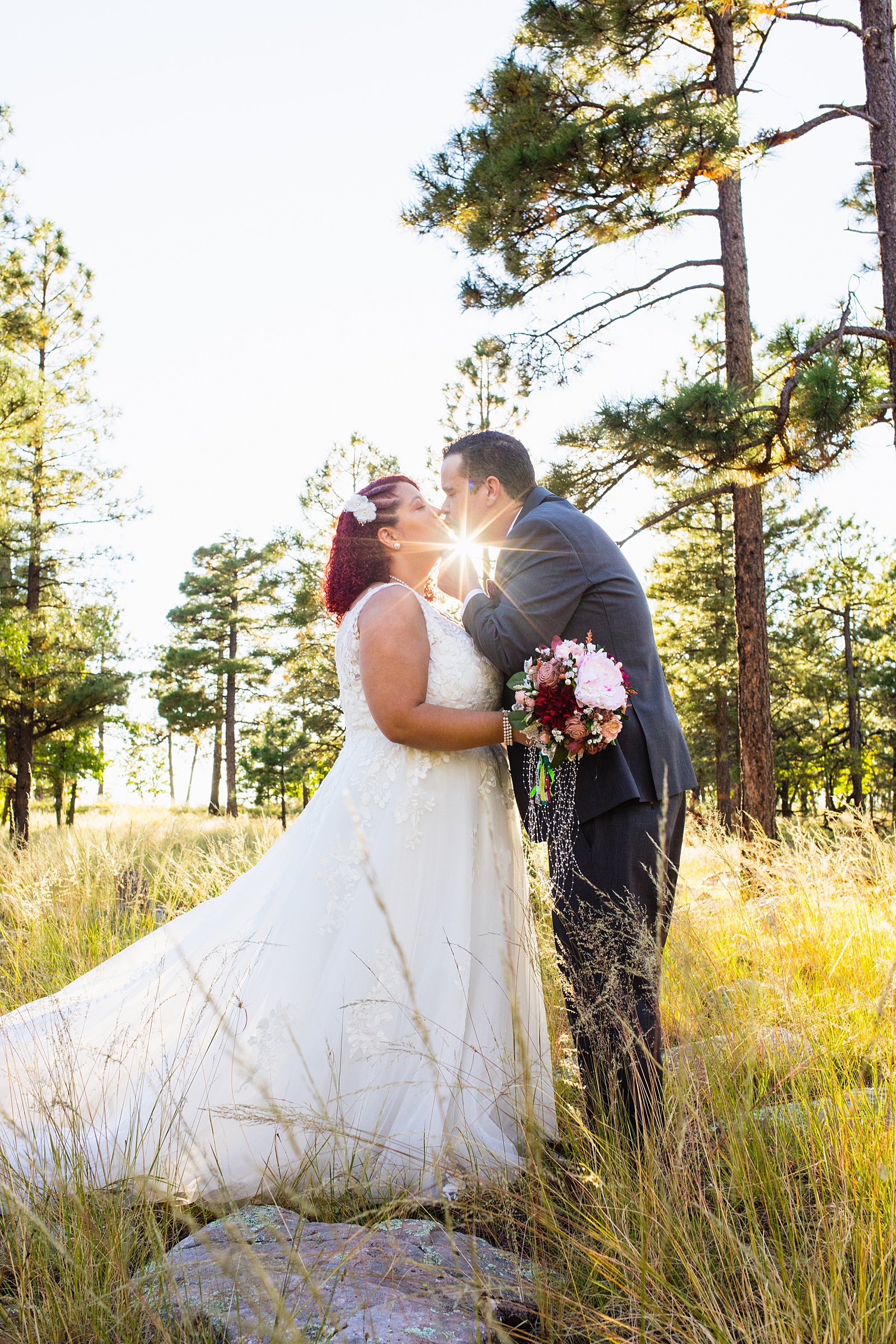 Adventurous couple share a kiss during their Mogollon Rim elopement by Arizona elopement photographer PMA Photography.