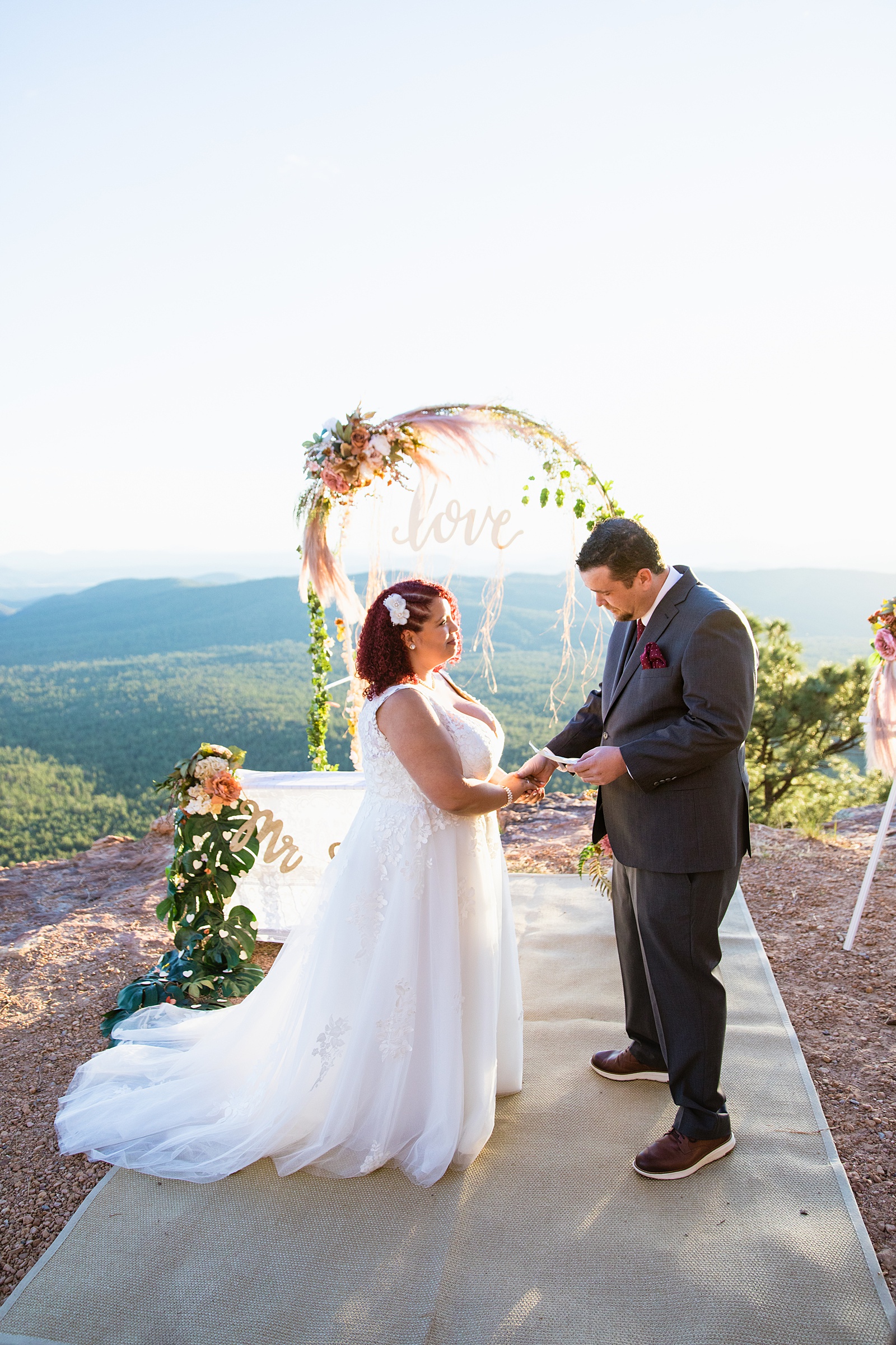 Adventurous couple exchange vows during their wedding ceremony at Mogollon Rim by Arizona elopement photographer PMA Photography.