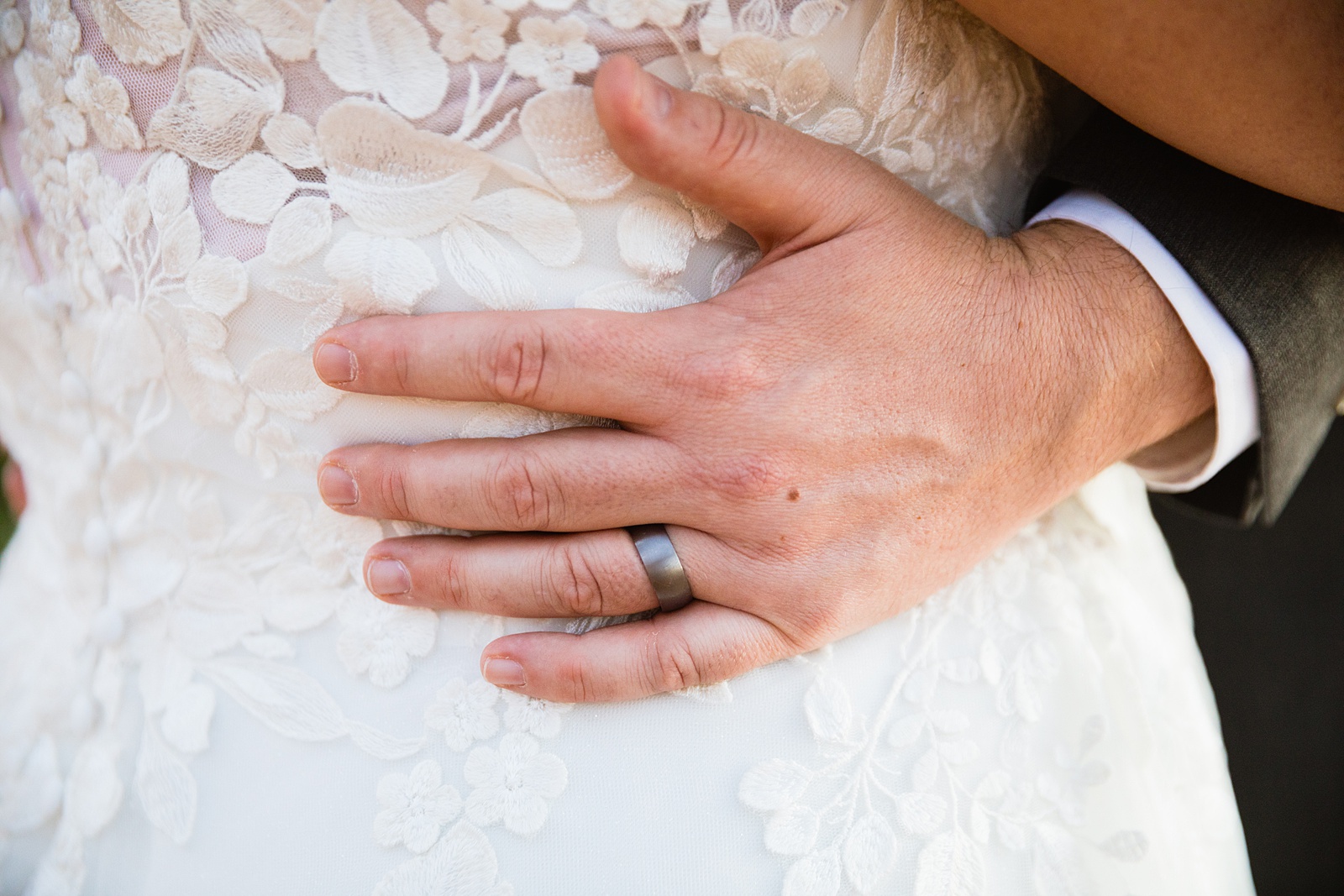 Groom's wedding ring detail as couple looks at each other at their Mogollon Rim elopement by Northern Arizona elopement photographer PMA Photography.