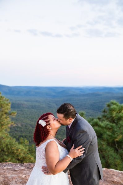 Adventurous couple share a kiss after their Mogollon Rim elopement by Northern Arizona elopement photographer PMA Photography.