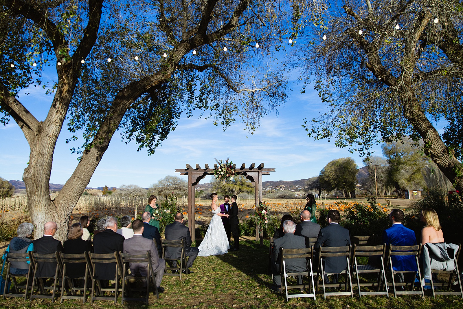 Same sex couple togethering during Mortimer Farms wedding ceremony by Prescott wedding photographer PMA Photography.