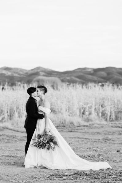 Same sex couple's first look at Mortimer Farms and share a kiss by Arizona wedding photographer PMA Photography.