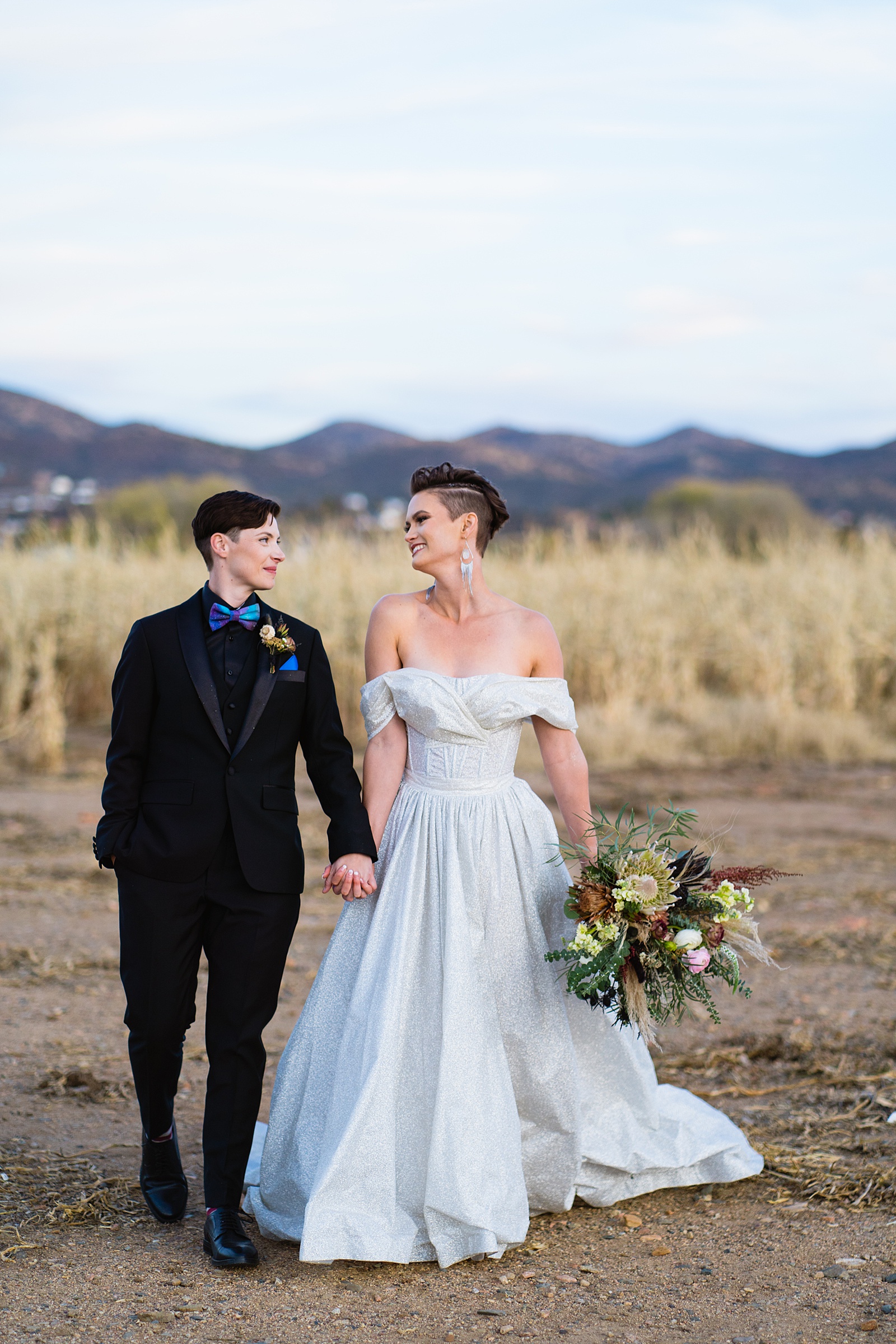 Same sex couple looking at each other during their Mortimer Farms wedding by Prescott wedding photographer PMA Photography.