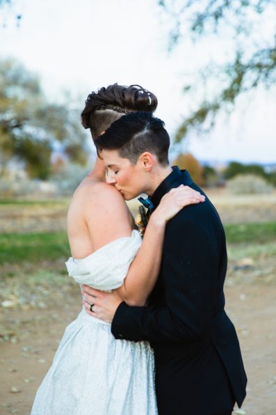Same sex couple share a sweet kiss during their Mortimer Farms wedding by Arizona wedding photographer PMA Photography.