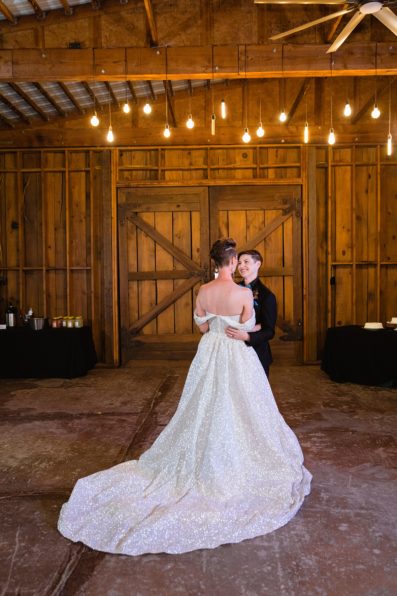 Same sex couple sharing first dance at their Mortimer Farms wedding reception by Arizona wedding photographer PMA Photography.