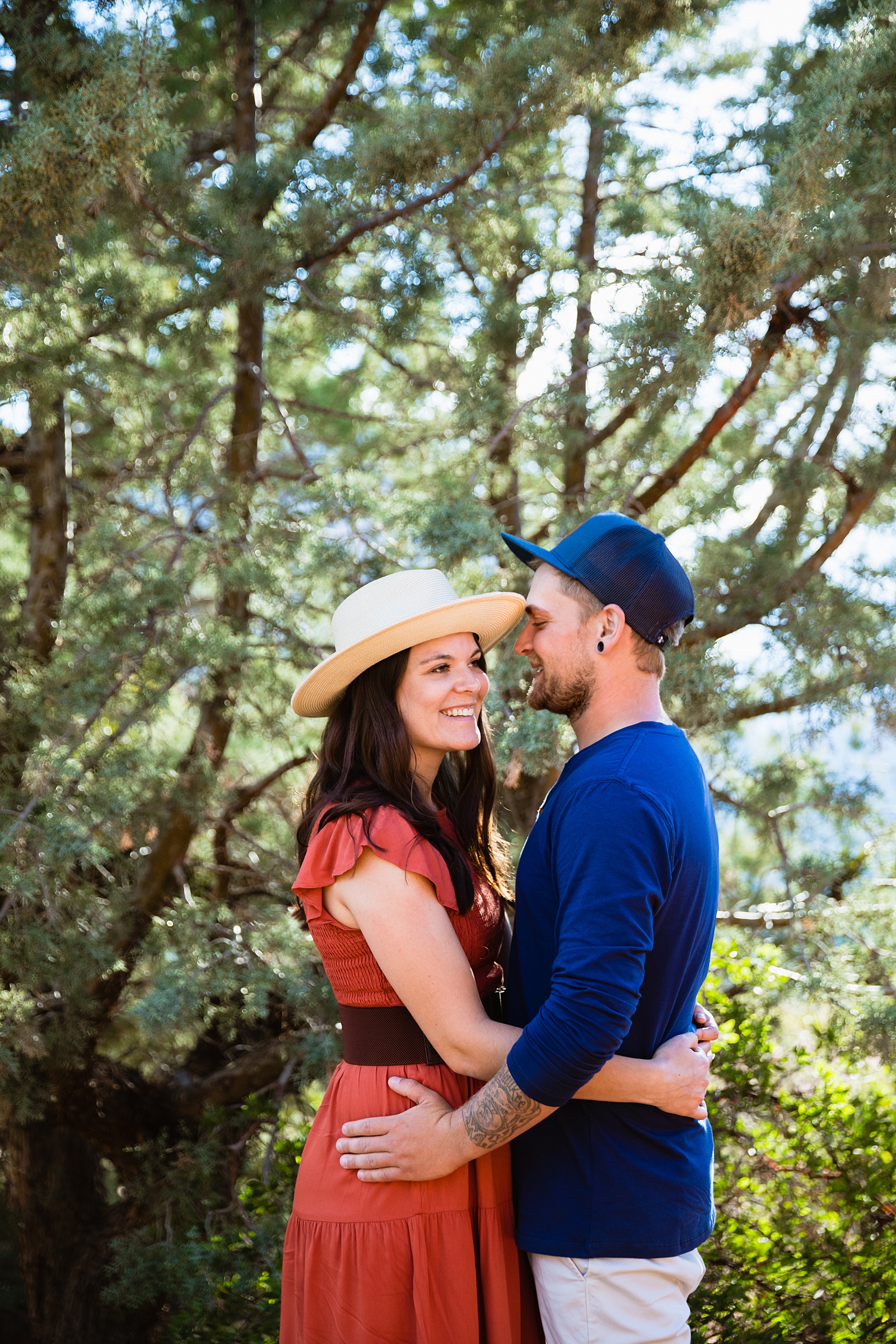Adventurous couple look at each other during their Merry Go Round Rock engagement session by Sedona wedding photographer PMA Photography.