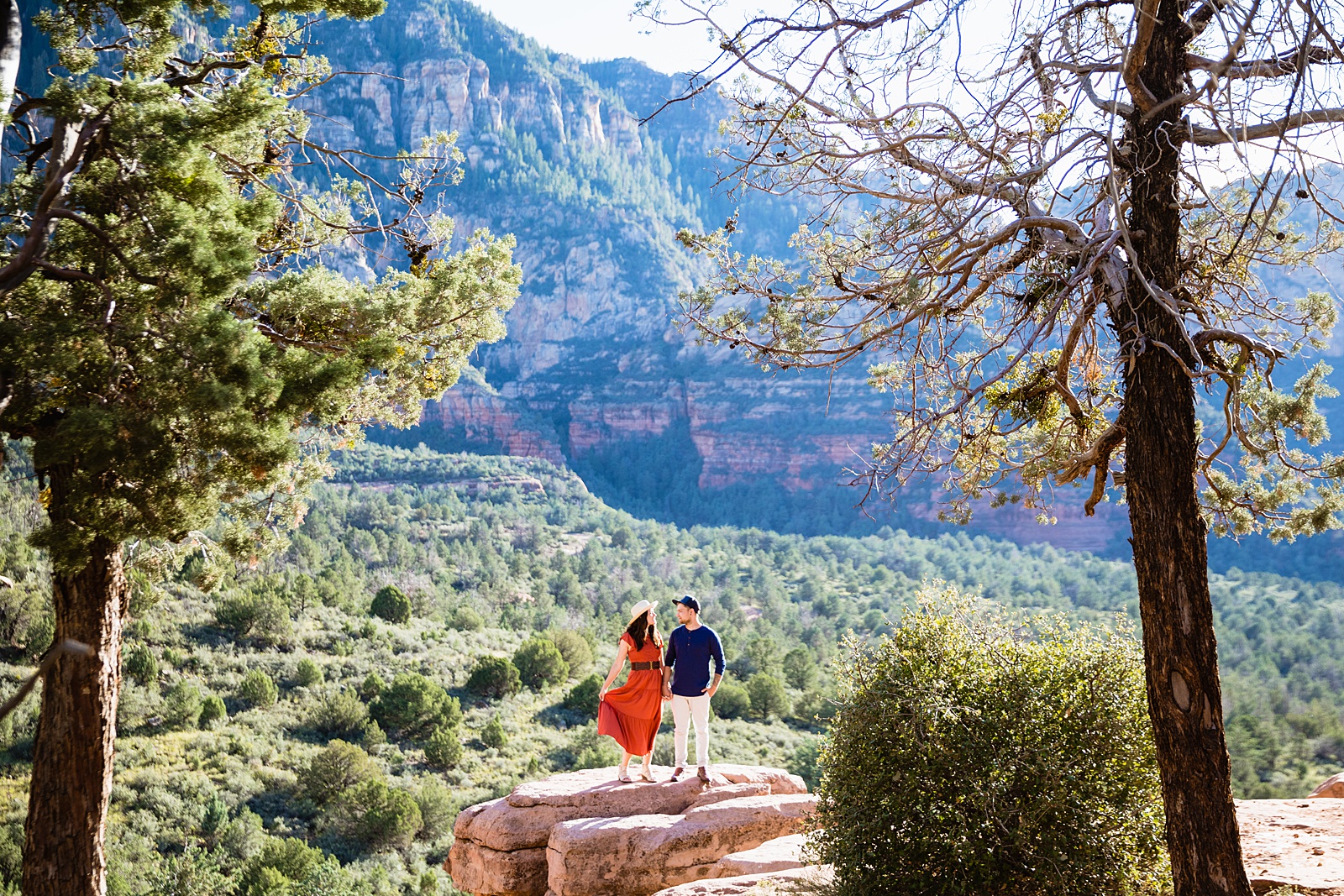 Adventurous couple walking together during their Merry Go Round engagement session by Sedona engagement photographer PMA Photography.