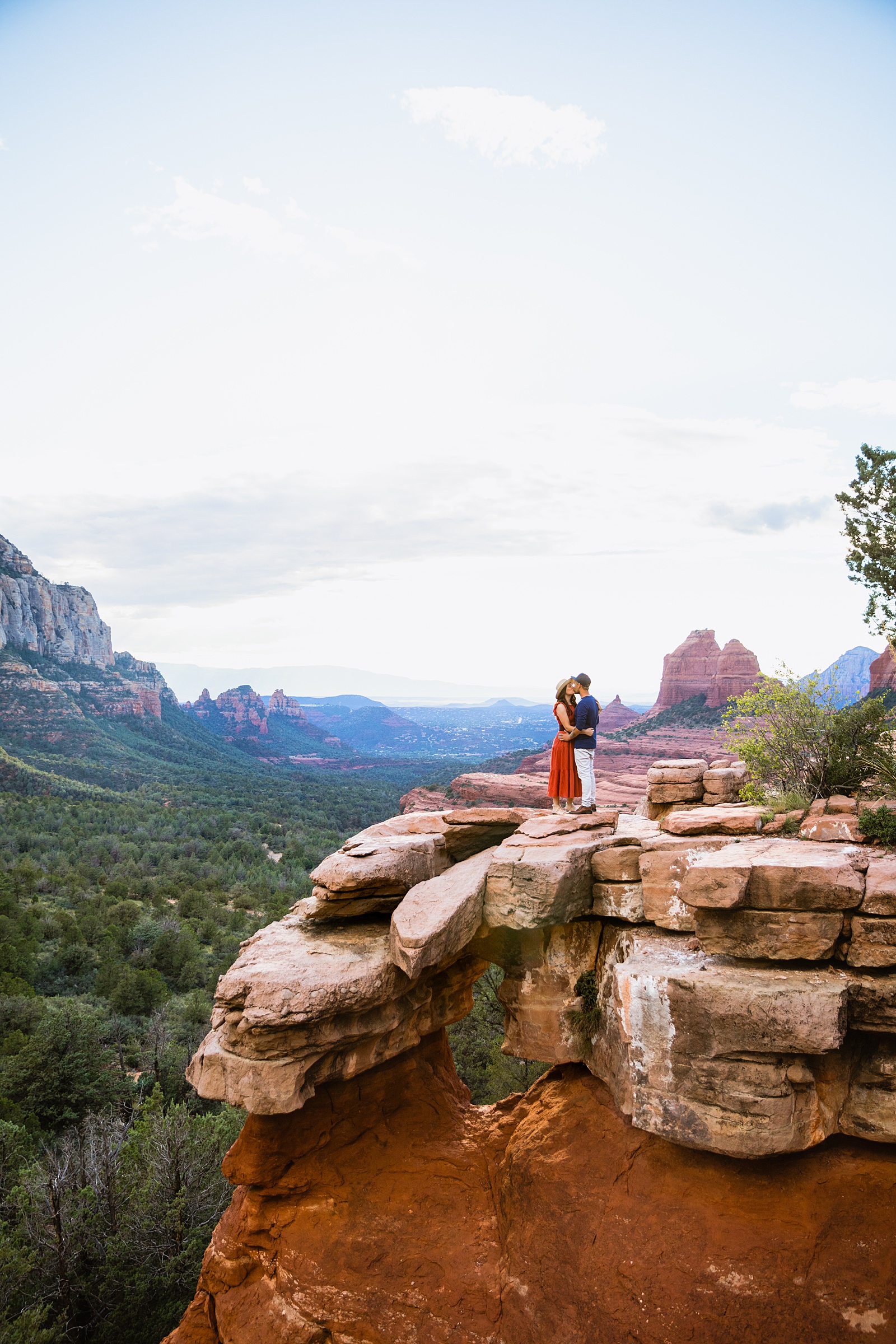 Couple share a kiss during their Sedona engagement session by Arizona wedding photographer PMA Photography.