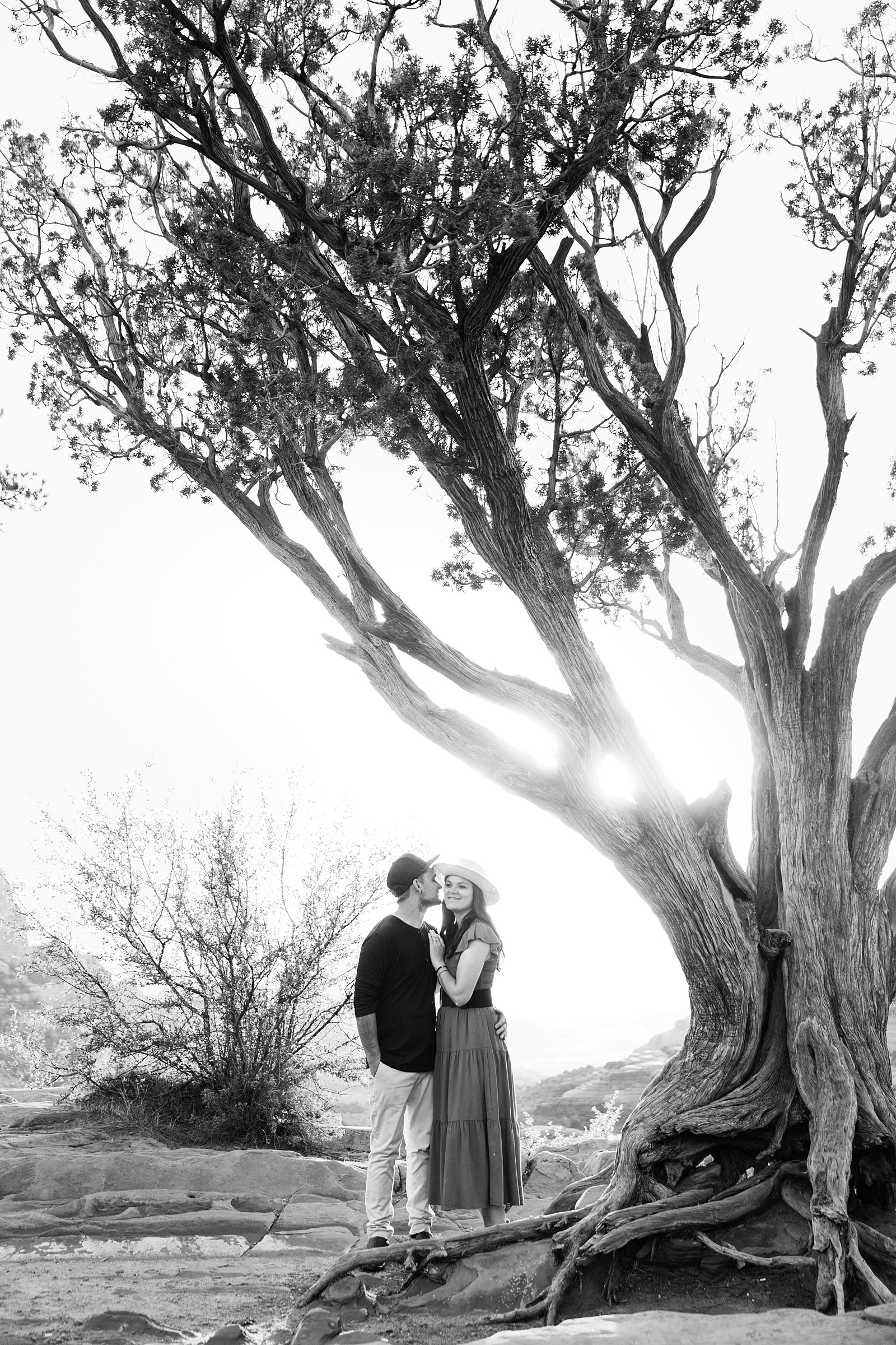 Couple share a kiss during their Sedona engagement session by Arizona wedding photographer PMA Photography.