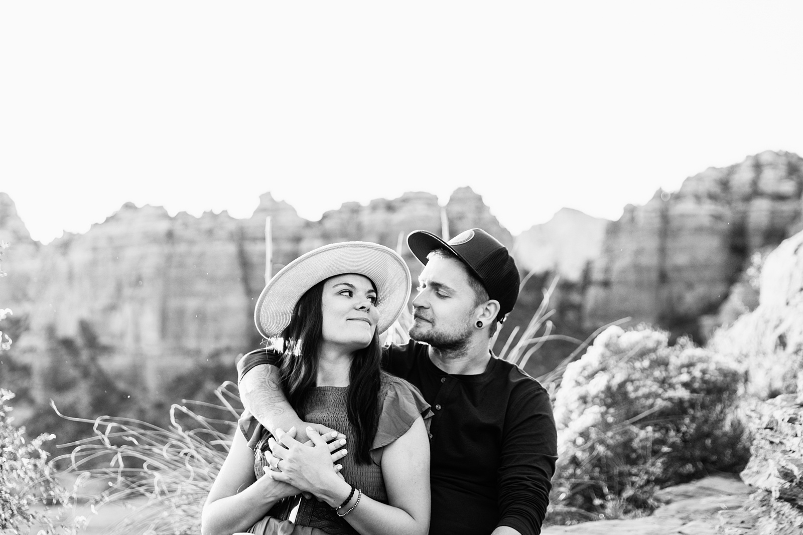 Adventurous couple pose for their Merry Go Round Rock engagement session by Sedona wedding photographer PMA Photography.