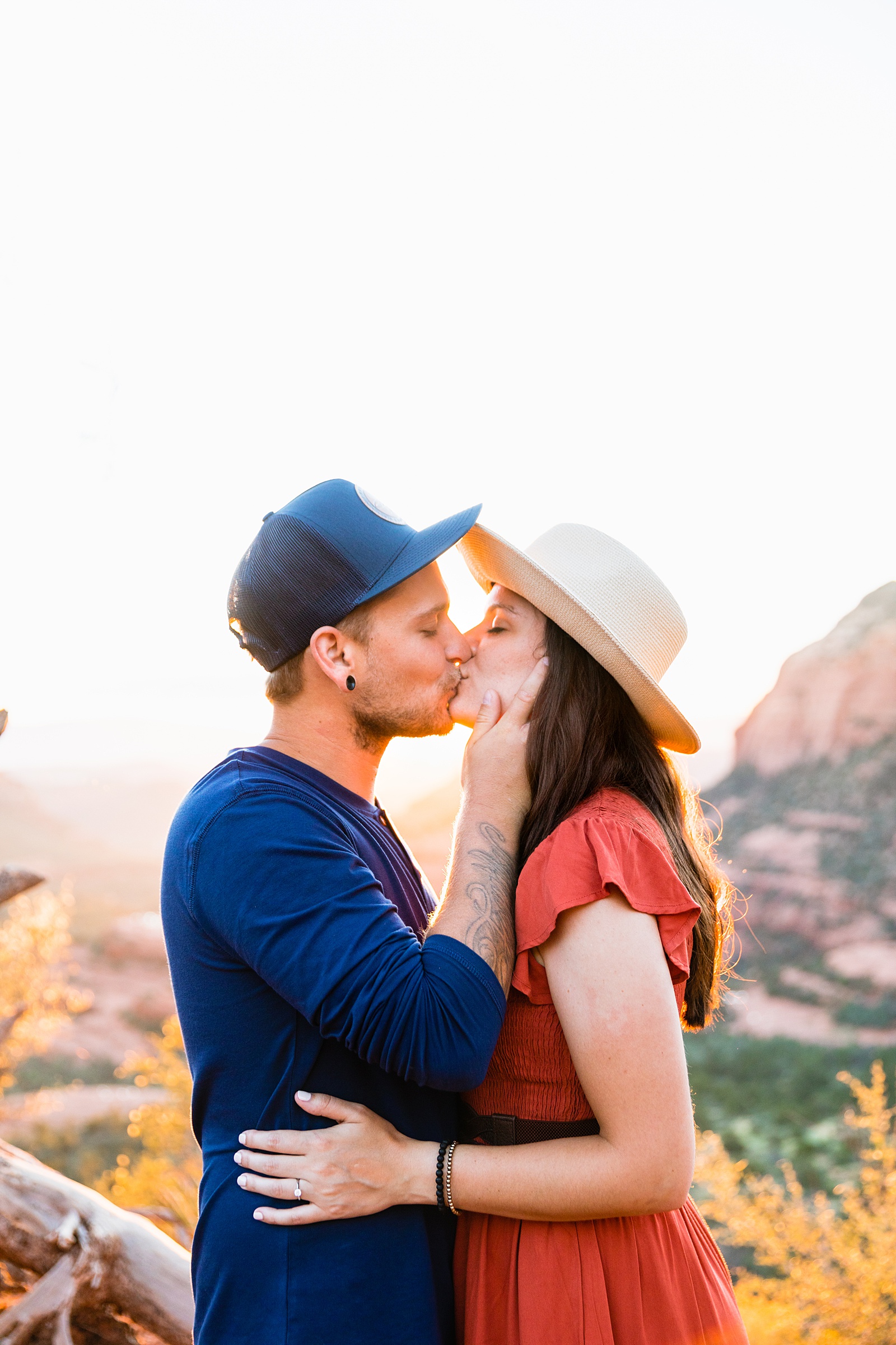 Couple share a kiss during their Merry Go Round Rock engagement session by Sedona wedding photographer PMA Photography.