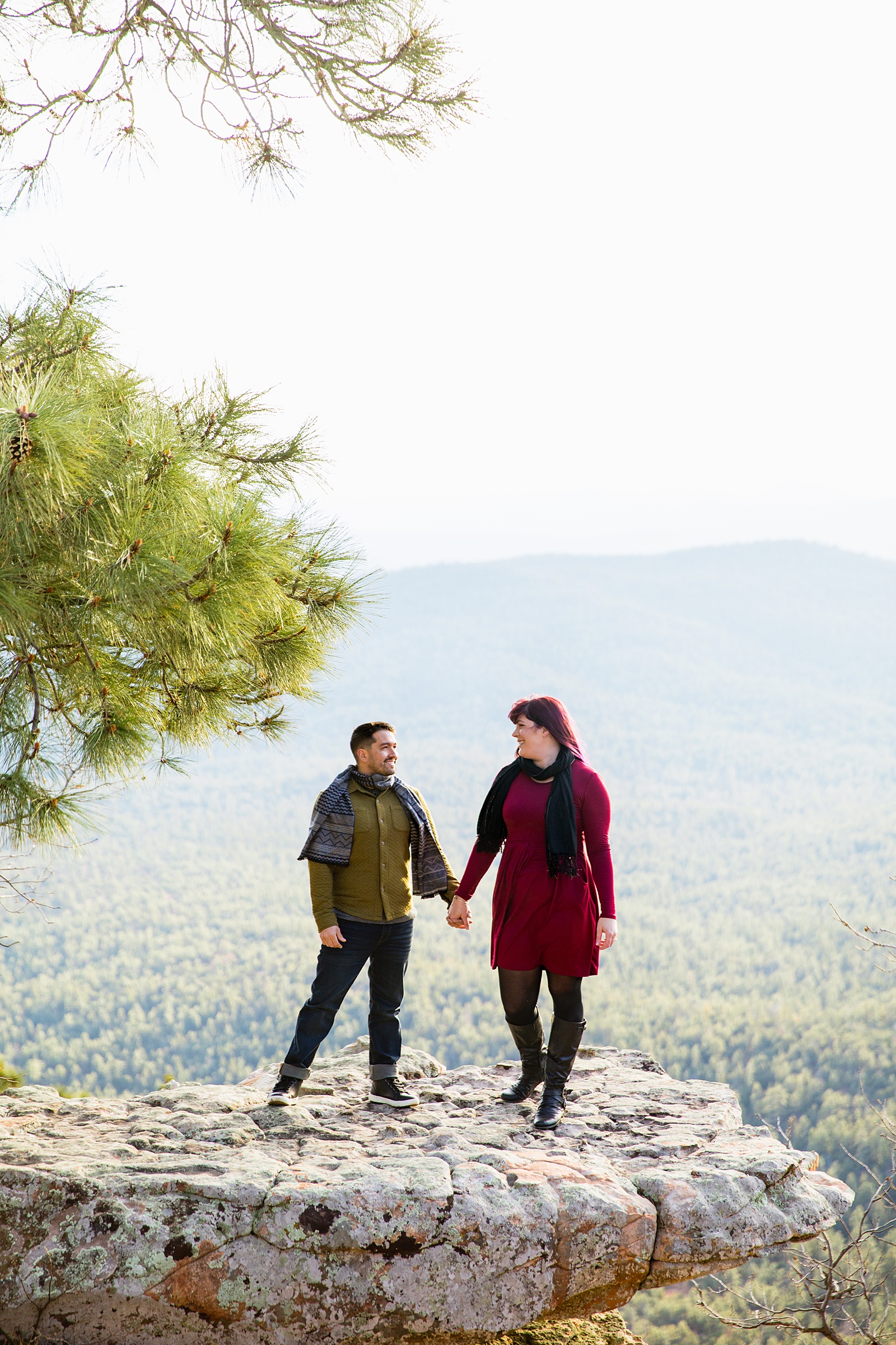 Adventurous look at each other during their Mogollon Rim engagement session by Payson wedding photographer PMA Photography.