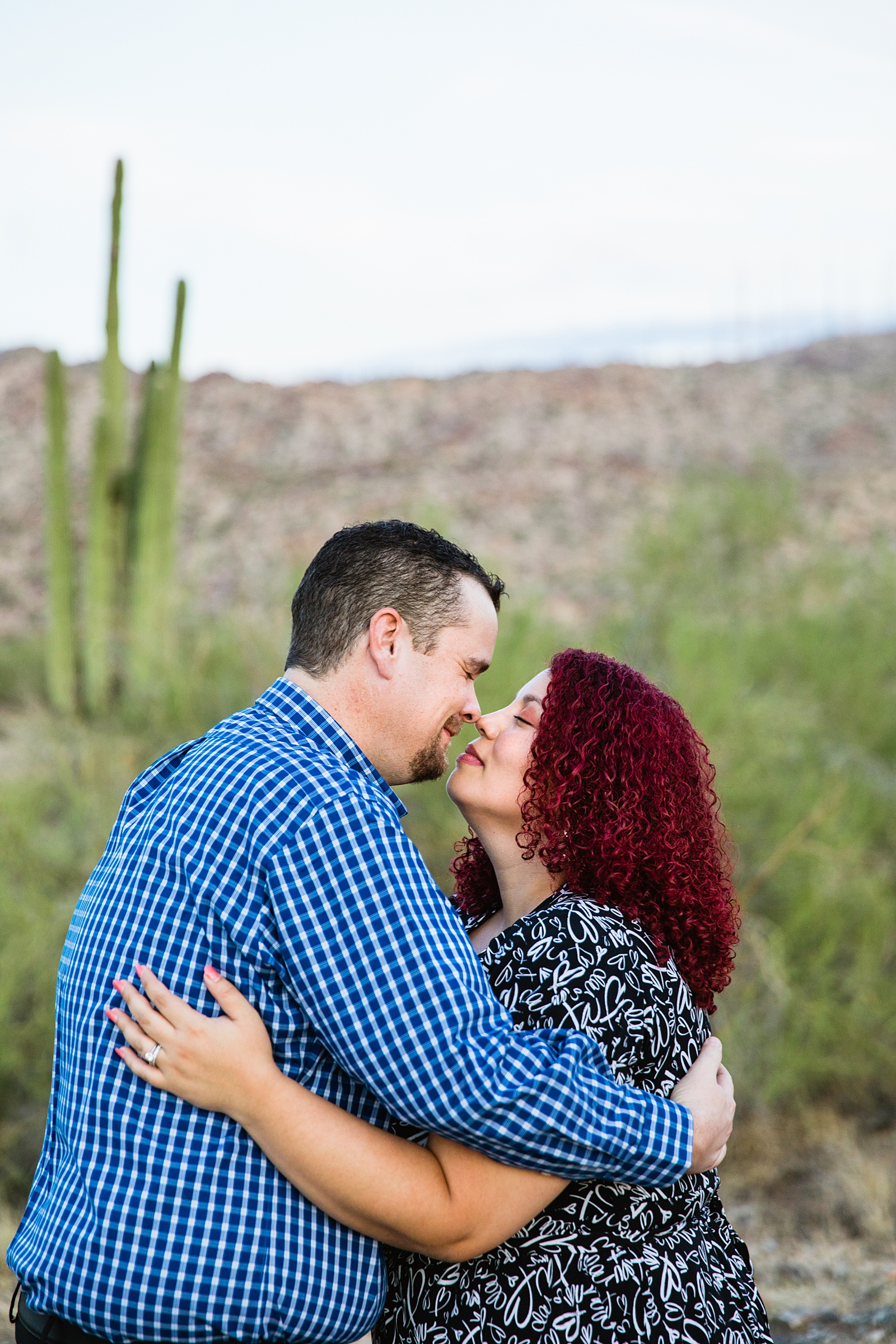 Couple look at each other during their South Mountain engagement session by Phoenix wedding photographer PMA Photography.