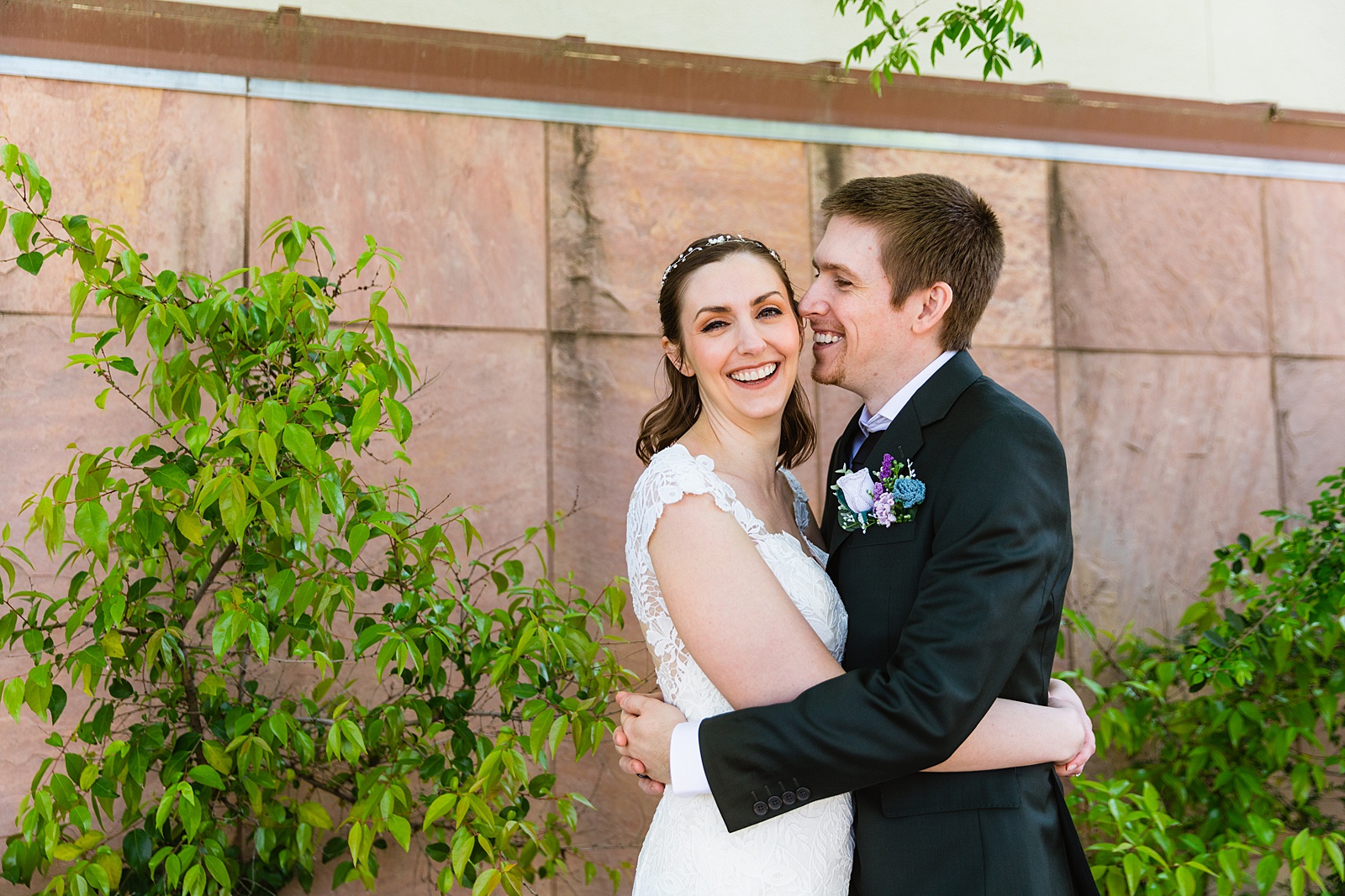 Bride and groom laughing together during their Chandler Community Center wedding by Chandler wedding photographer PMA Photography.