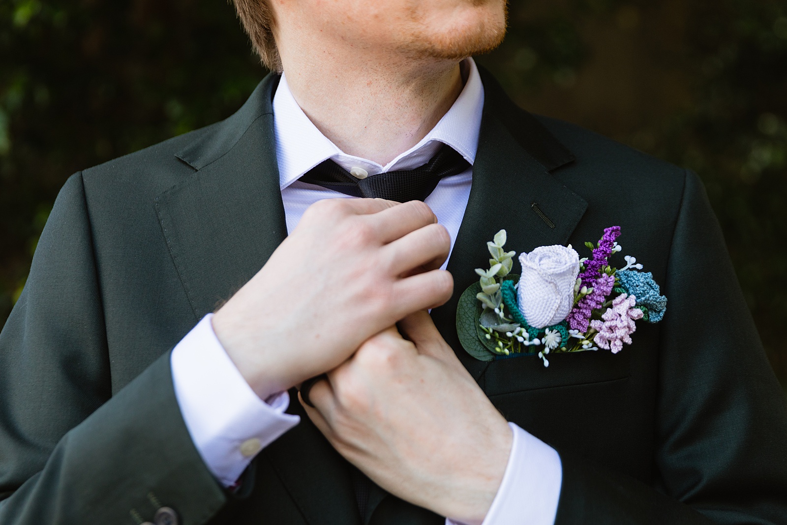 Groom adjusting his tie for his wedding day by Chandler wedding photographers PMA Photography.