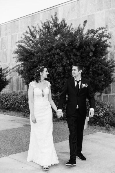 Bride and groom walking together during their Chandler Community Center wedding by Chandler wedding photographer PMA Photography.