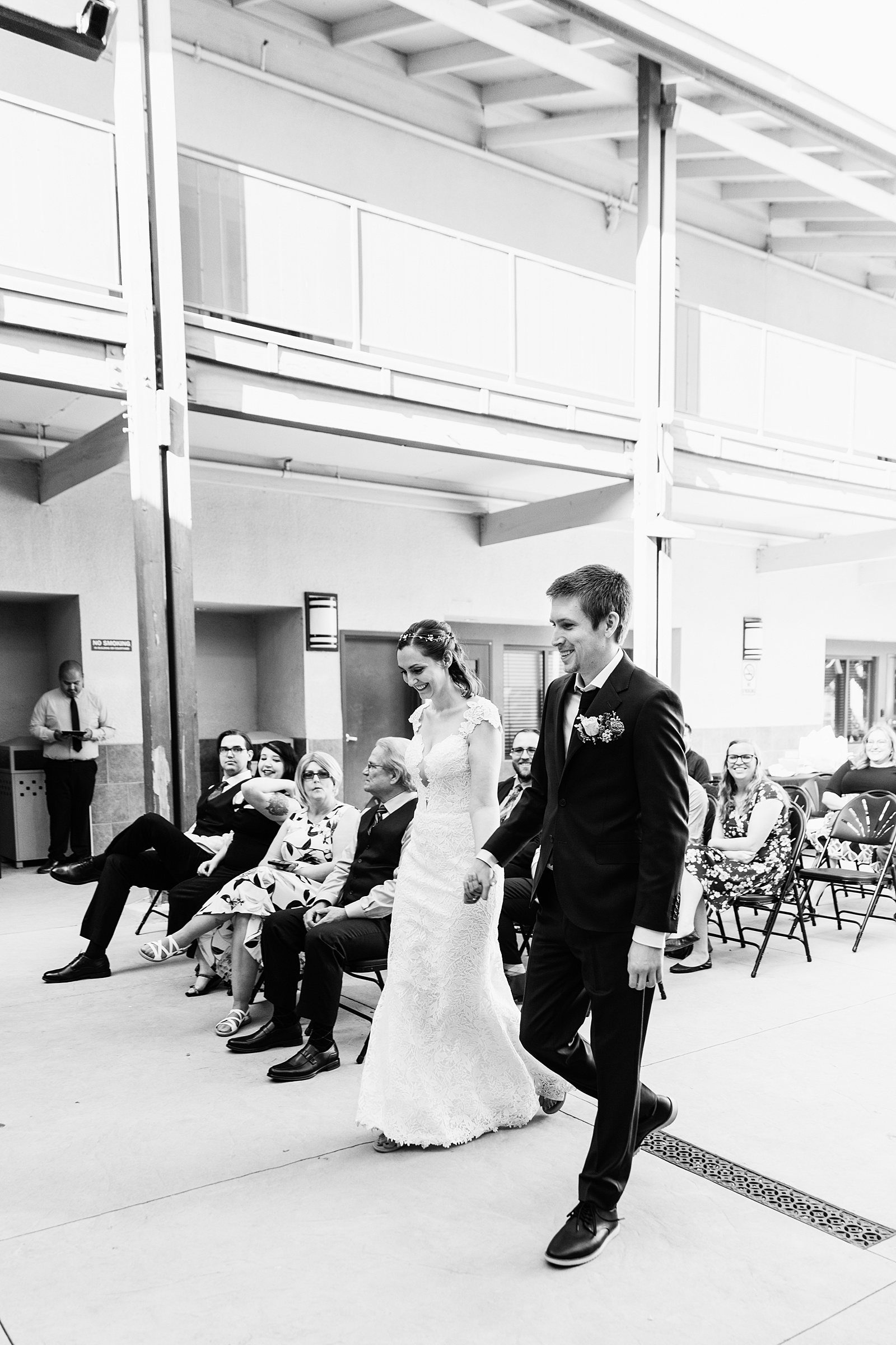 Bride and groom walking down aisle during Chandler Community Center wedding ceremony by Phoenix wedding photographer PMA Photography.