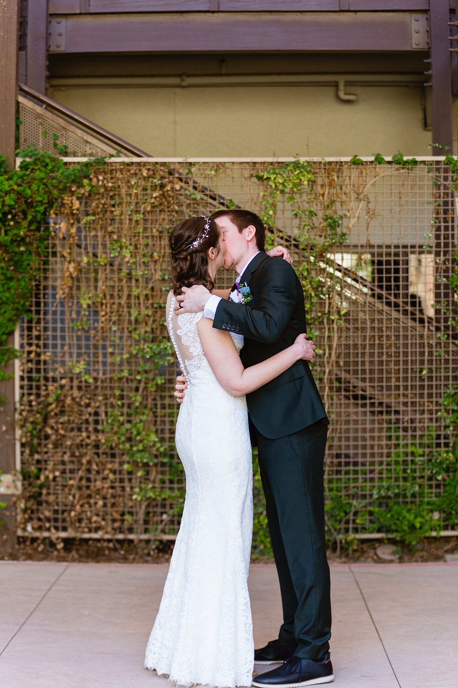 Bride and groom share their first kiss during their wedding ceremony at Chandler Community Center by Arizona wedding photographer PMA Photography.