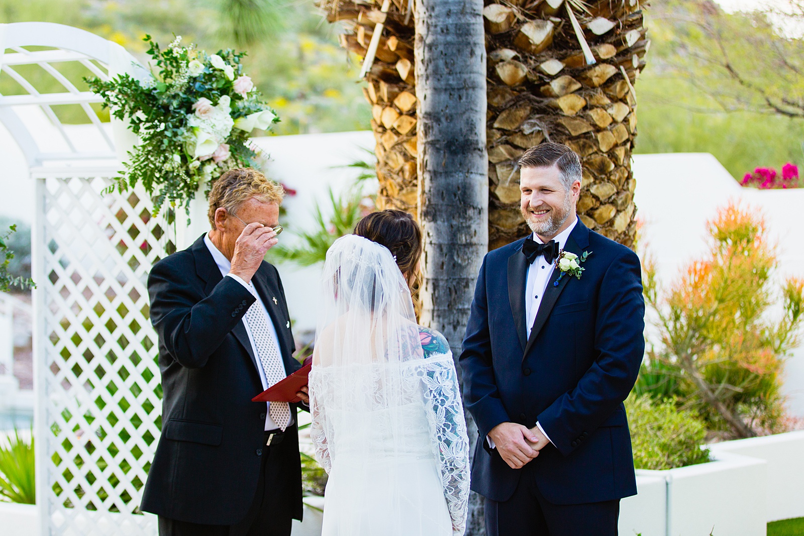 Groom looking at his bride during their wedding ceremony at backyard by Scottsdale wedding photographer PMA Photography.