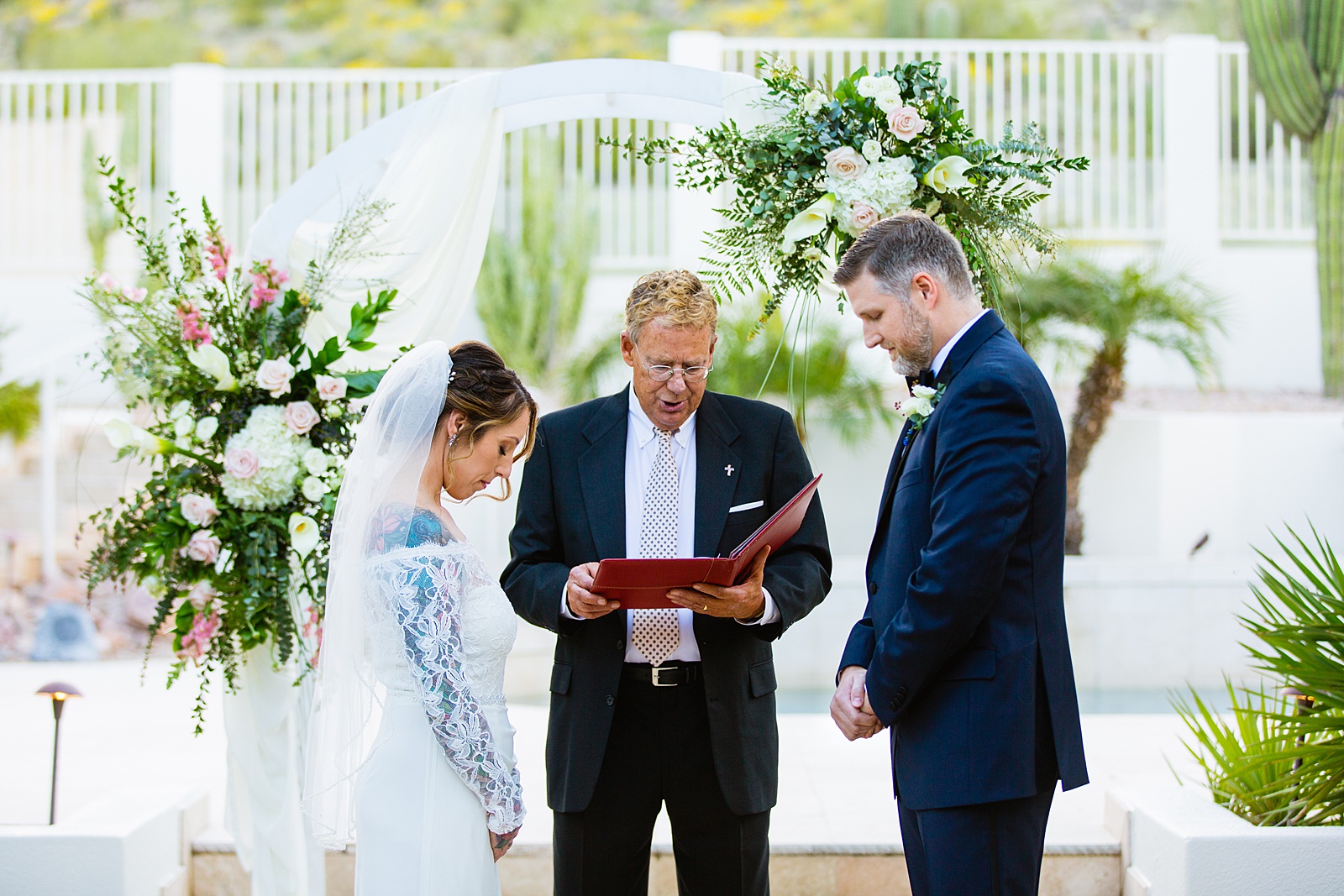 Bride and groom together during backyard wedding ceremony by Scottsdale wedding photographer PMA Photography.