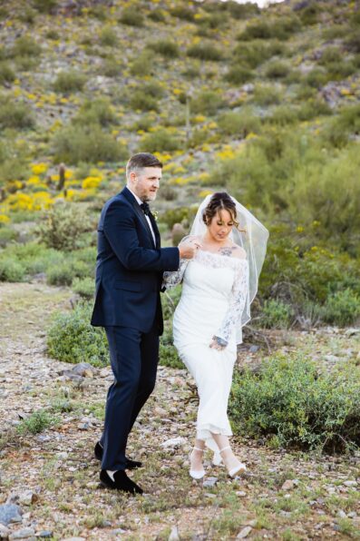 Bride and groom walking together during their backyard wedding by Arizona wedding photographer PMA Photography.