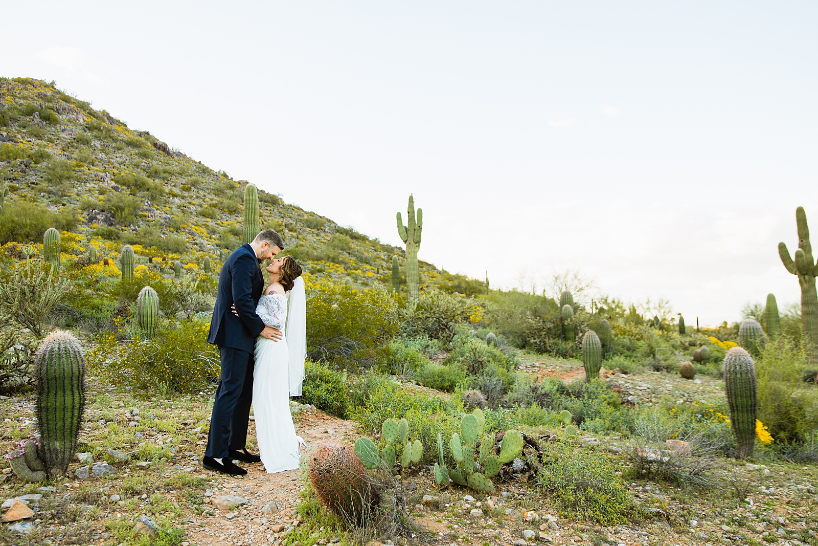 Bride and groom pose for their backyard wedding by Scottsdale wedding photographer PMA Photography.