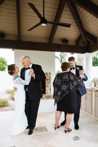 Bride and groom dancing with guests at their backyard wedding reception by Arizona wedding photographer PMA Photography