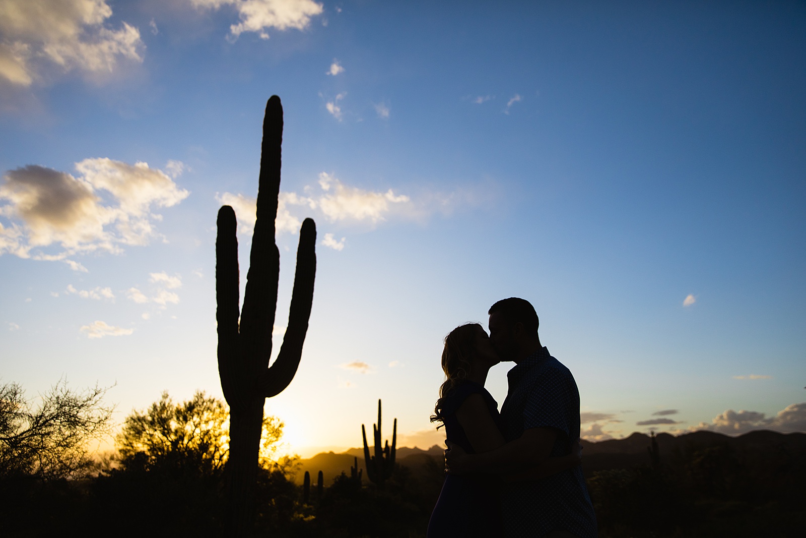 Couple share a kiss during their Apache Junction engagement session by Arizona wedding photographer PMA Photography.
