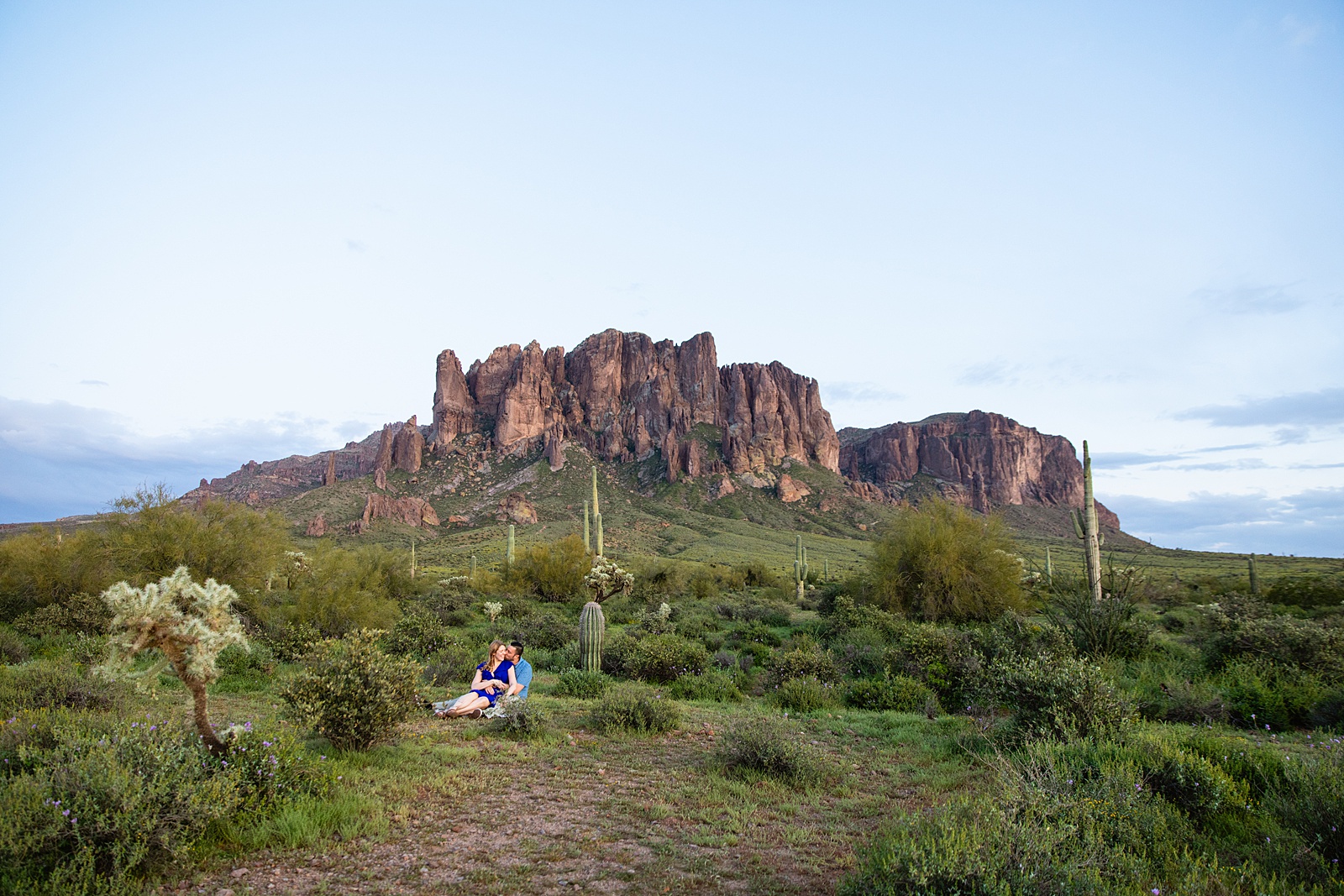 Couple share an intimate moment during their Superstitions Mountain engagement session by Apache Junction engagement photographer PMA Photography.