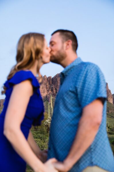 Couple share a kiss during their Superstitions Mountain engagement session by Apache Junction wedding photographer PMA Photography.