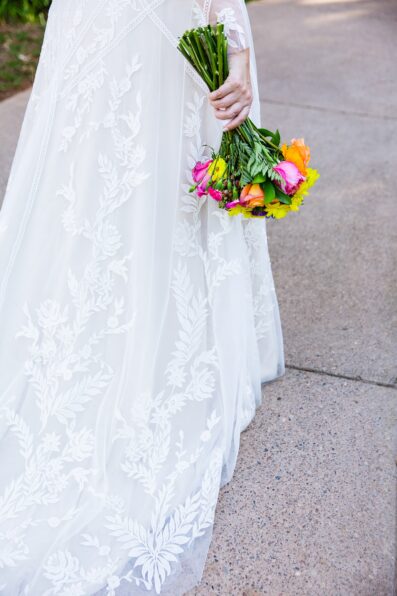 Bride's bright and bold colorful bouquet and embroidered dress by PMA Photography.