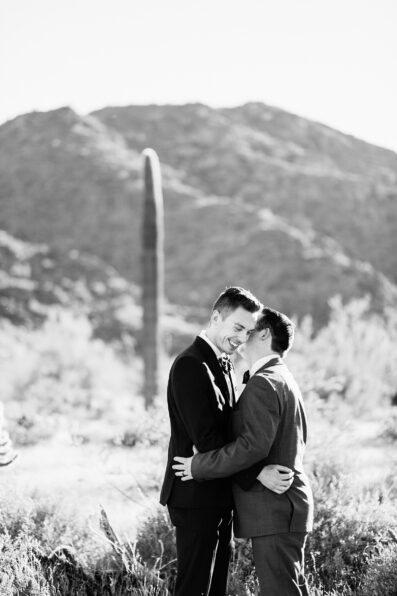 LGBTQ couple share an intimate moment during their first look at White Tanks by Arizona elopement photographer PMA Photography.