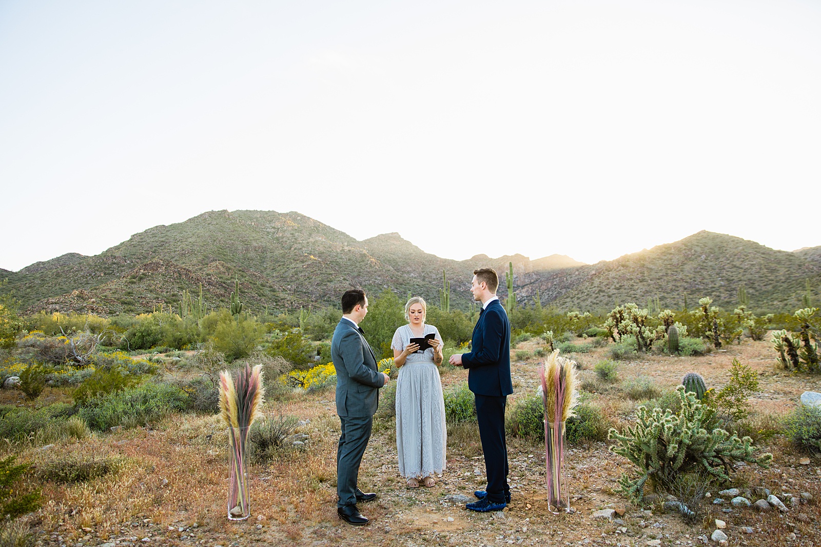 LGBTQ couple exchange rings during their wedding ceremony at White Tanks by Arizona elopement photographer PMA Photography.
