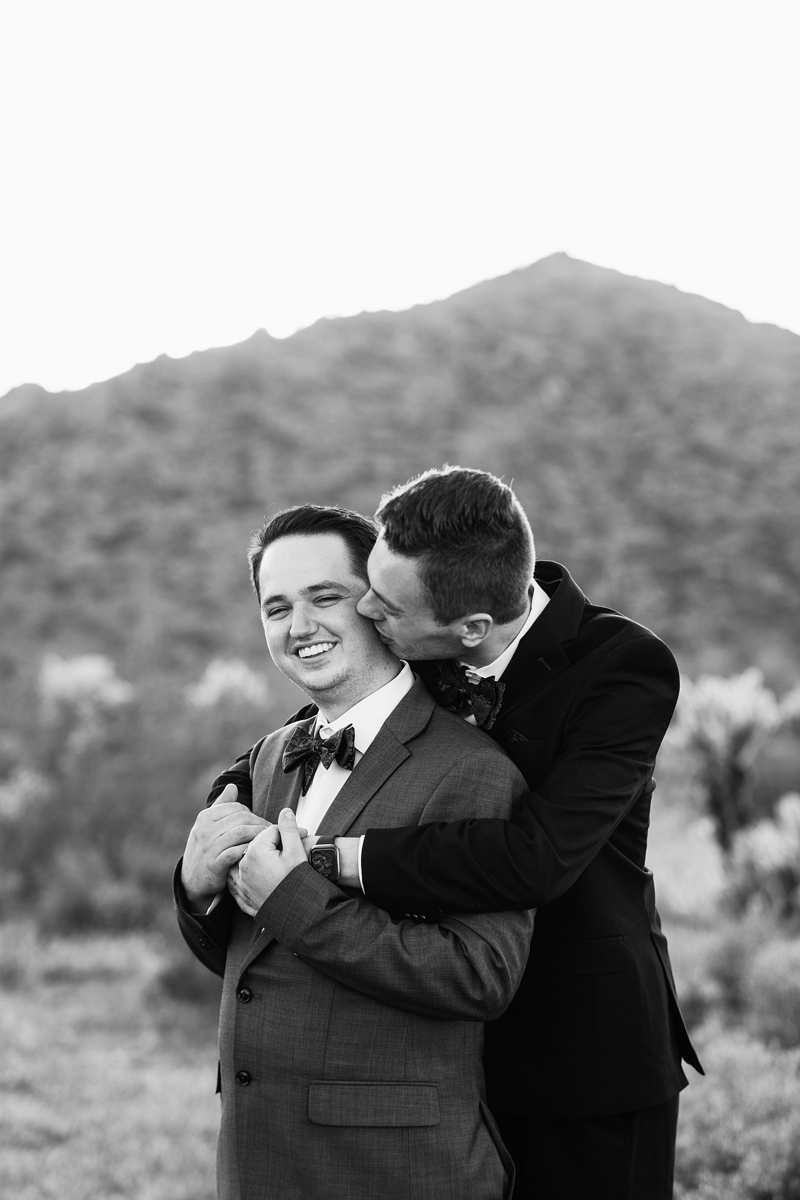 LGBTQ couple share a kiss during their White Tanks elopement by Phoenix elopement photographer PMA Photography.