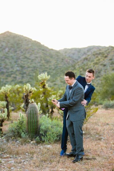 LGBTQ couple share a bottle of champange at their Phoenix elopement by Arizona elopement photographer PMA Photography.