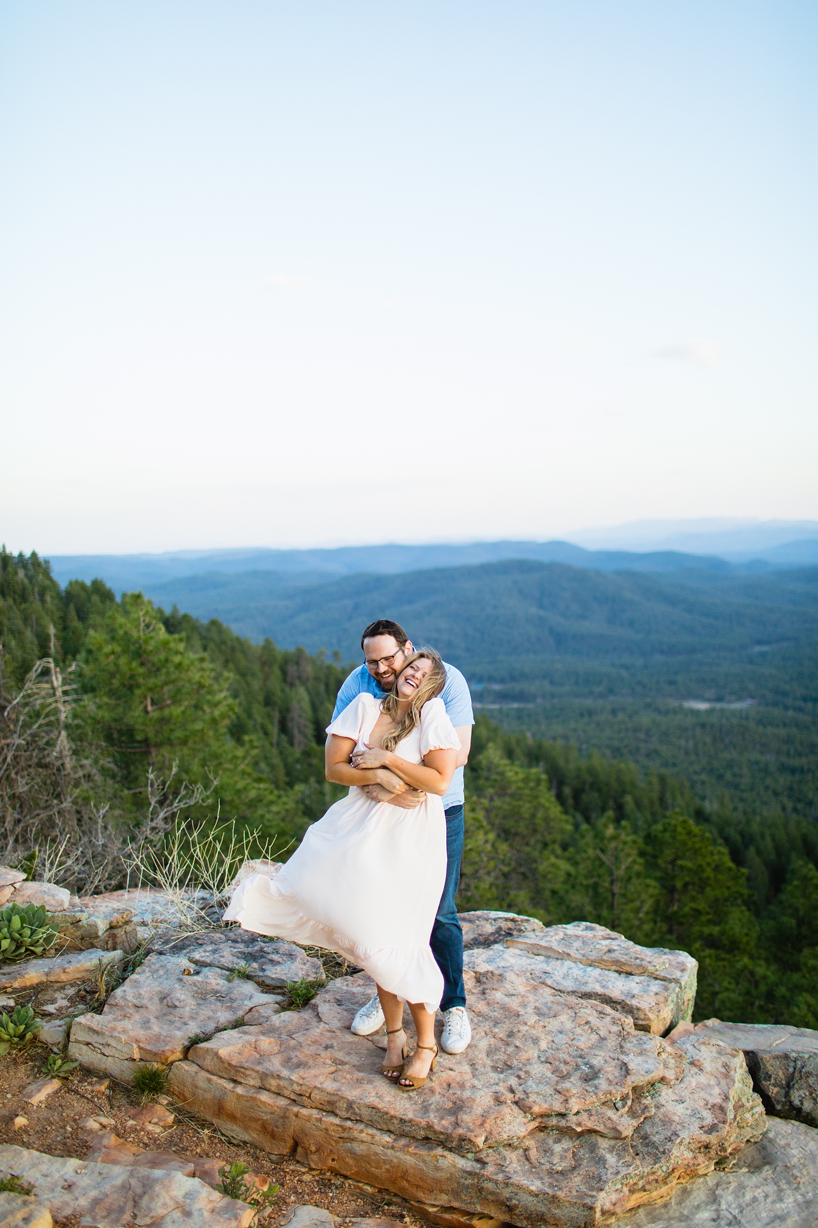 Adventurous couple laugh together during their Mogollon Rim engagement session by Payson engagement photographer PMA Photography.