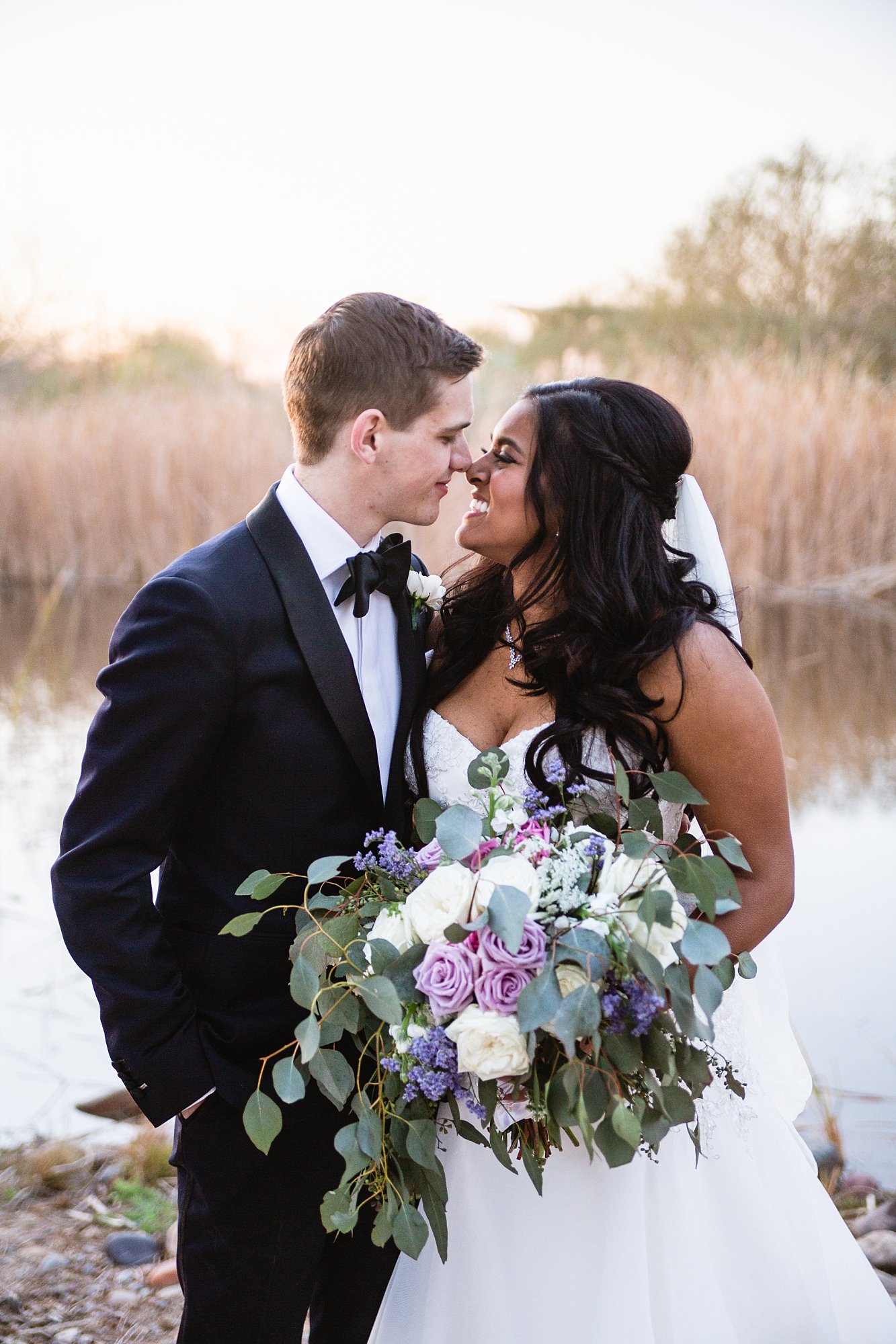 Bride and groom sharing an intimate moment on their wedding day at the Rio Salado Audubon in Phoenix by wedding photographers PMA Photography.