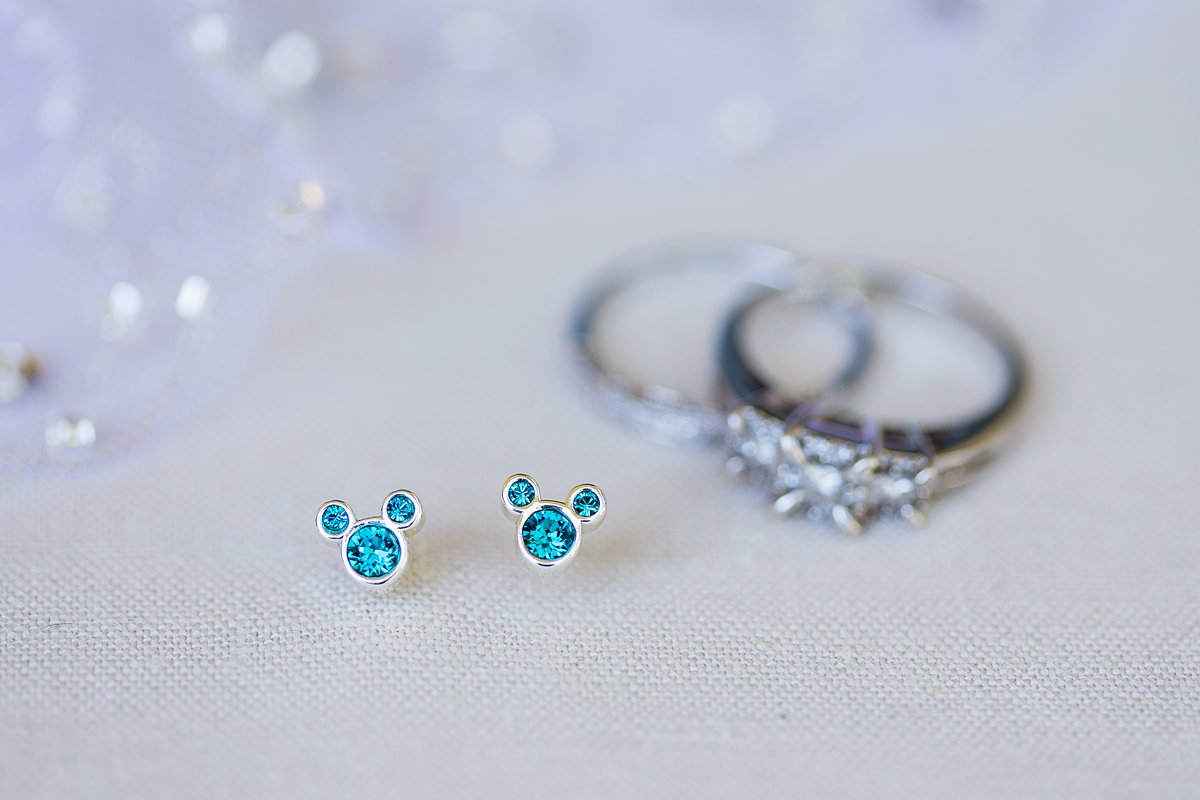 Bride's something blue Disney Mickey Mouse ear rings with her wedding rings by PMA Photography.