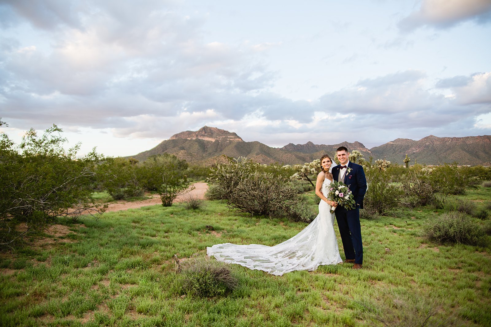Bride and groom in the desert at for their Spring wedding by Phoenix wedding photographer PMA Photography.