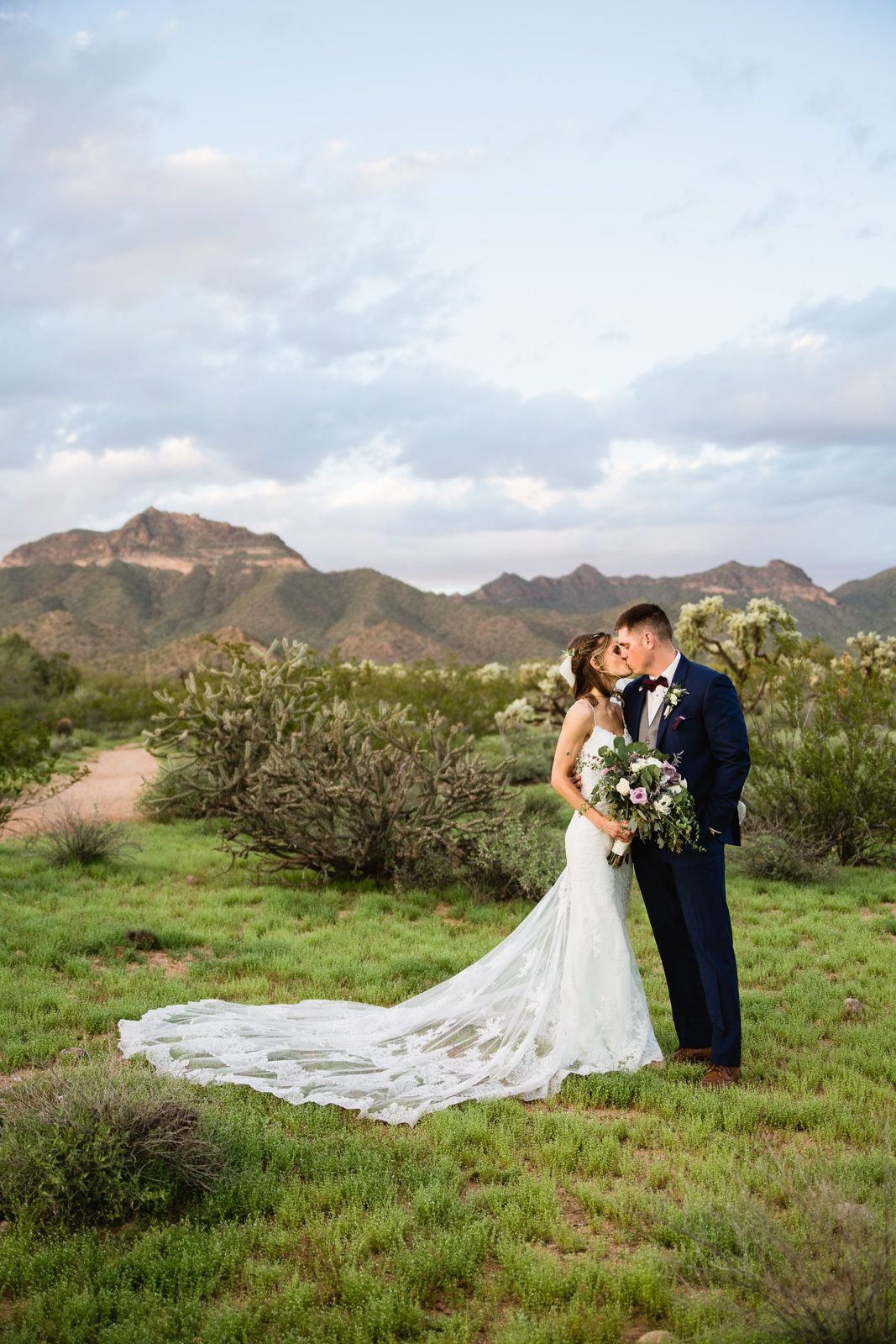 Bride and groom share a romantic kiss in the desert at their Superstition Manor Wedding by Mesa wedding photographer PMA Photography.